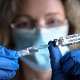 COVID-19 vaccine in researcher hands, female doctor holds syringe and bottle with vaccine for coronavirus cure